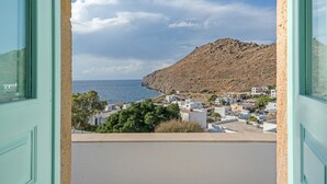 A coastal town with buildings, a mountain, and the sea.