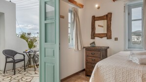A bedroom with a bed, a dresser, a mirror, and a window.