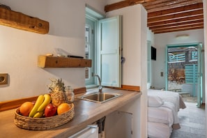 Una cocina con encimera de madera, cesta de frutas y un fregadero.