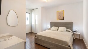 A bedroom with a large bed, bedside tables, a wall-mounted artwork, and a window. - Apartment 'Appartamento Bettin' with Private Terrace, Wi-Fi and Air Conditioning (Caorle)