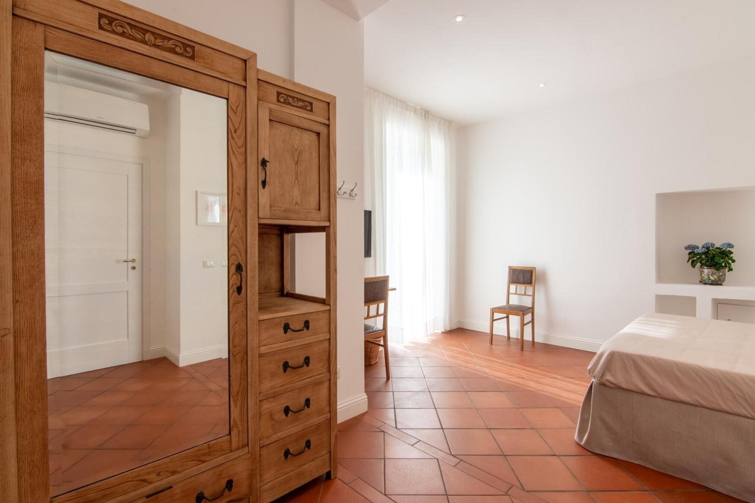 Une chambre à coucher avec une armoire en bois, un lit, un bureau et une chaise.