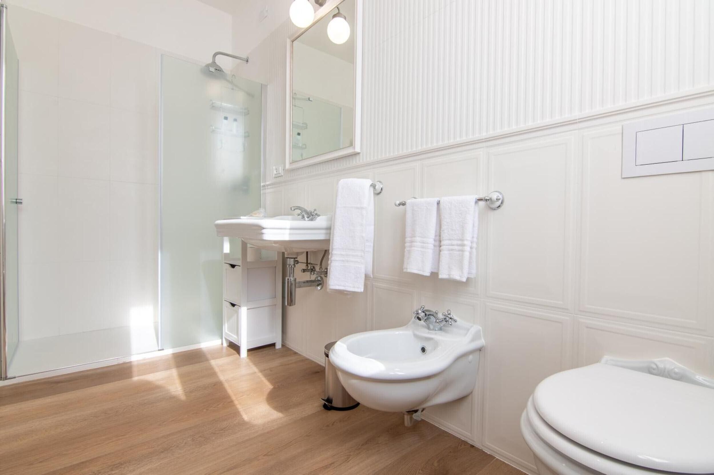 Une salle de bain moderne équipée d’une douche, d’un lavabo, d’un bidet et de toilettes.