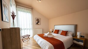 A bedroom with a large bed, a nightstand, a desk, a chair, and artwork on the walls. - Villa 'Casa El Rasillo' with Lake View, Private Terrace and Wi-Fi (El Rasillo de Cameros)