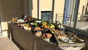 Une table de buffet proposant divers plats et offrant une vue sur l’extérieur.