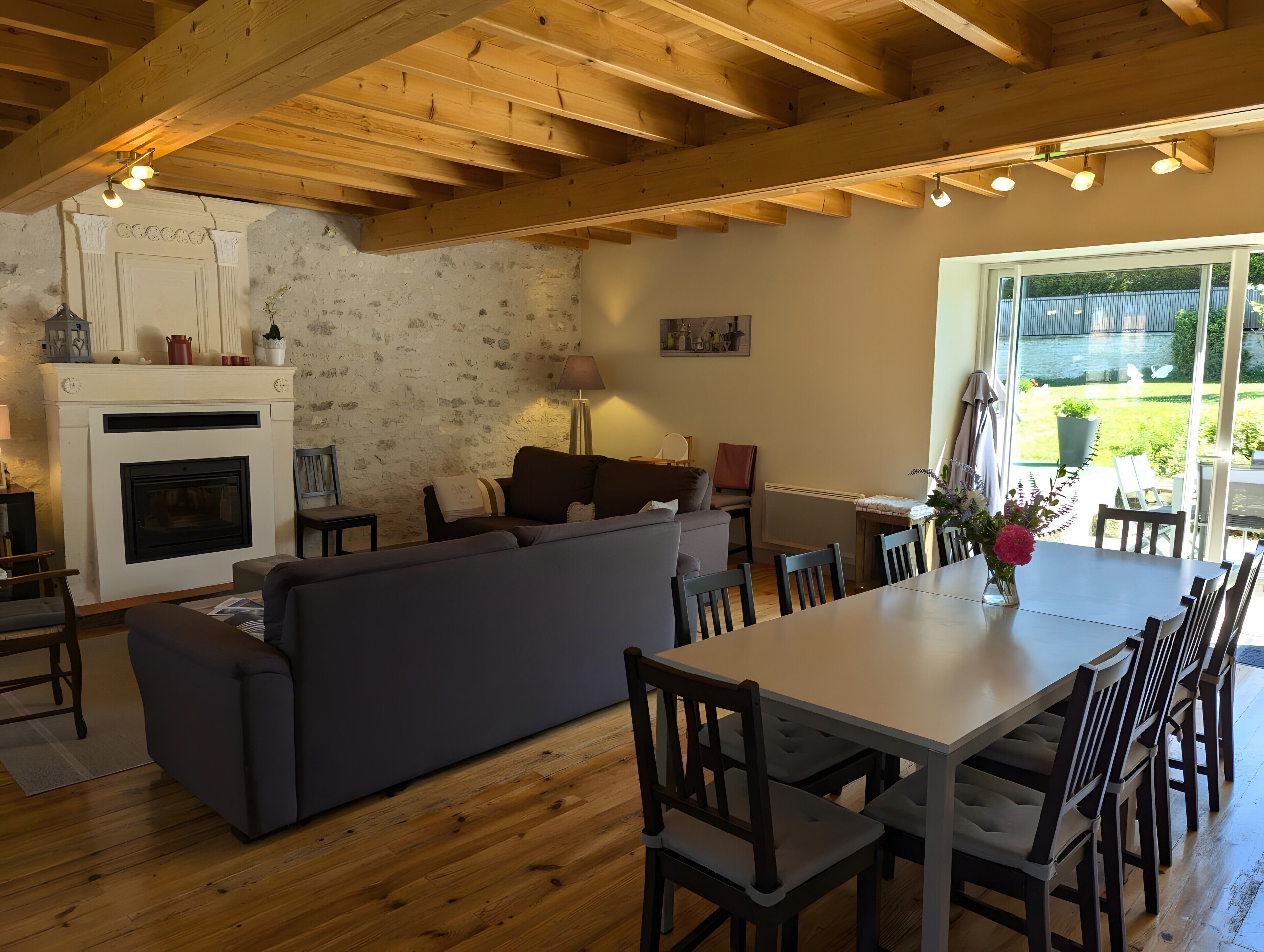 Un salon chaleureux avec une cheminée, un canapé, une table à manger et des chaises.