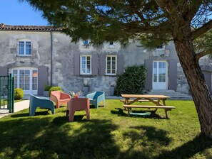 A stone building with a patio area featuring outdoor furniture and a picnic table. - Holiday Home 'La Bonne Chauffe - Serpentin' with Shared Pool, Private Terrace and Wi-Fi (Verrières)
