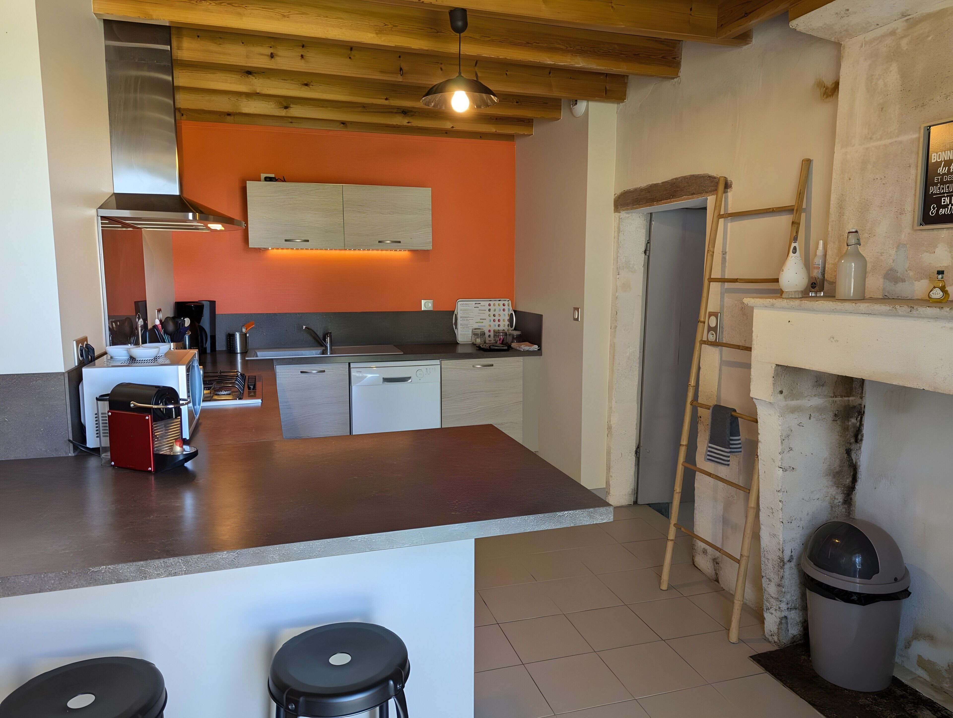 A kitchen with a wooden ceiling, a built-in oven, a sink, and a countertop.