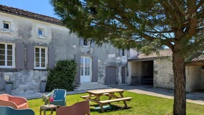 A courtyard with a picnic table, chairs, and a tree. - Holiday Home 'La Bonne Chauffe - Serpentin' with Shared Pool, Private Terrace and Wi-Fi (Verrières)