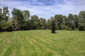 A grassy field with trees in the background. - Caravan 'Vue Sur L'étang' with Lake View, Shared Pool and Private Terrace (Champsac)