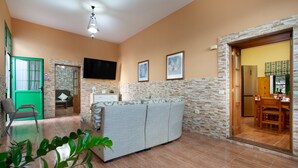A living room with a sofa, a TV, and a dining area with chairs and a table. - Holiday Home 'Casa Dayaday' with Mountain Views and Wi-Fi (Puerto del Rosario)