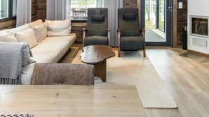 A cozy living room with a sofa, two armchairs, a coffee table, and a fireplace.