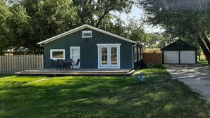 A single-story house with a deck, a garage, and a fenced yard.