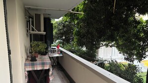 A balcony with a table, potted plants, and a red lamp. - Quiet Spacious Room.. Garden City, 2 Min to Nile (Cairo Governorate)