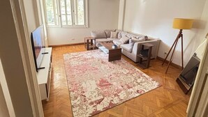 A living room with a sofa, coffee table, rug, and lamp. - Quiet Spacious Room.. Garden City, 2 Min to Nile (Cairo Governorate)