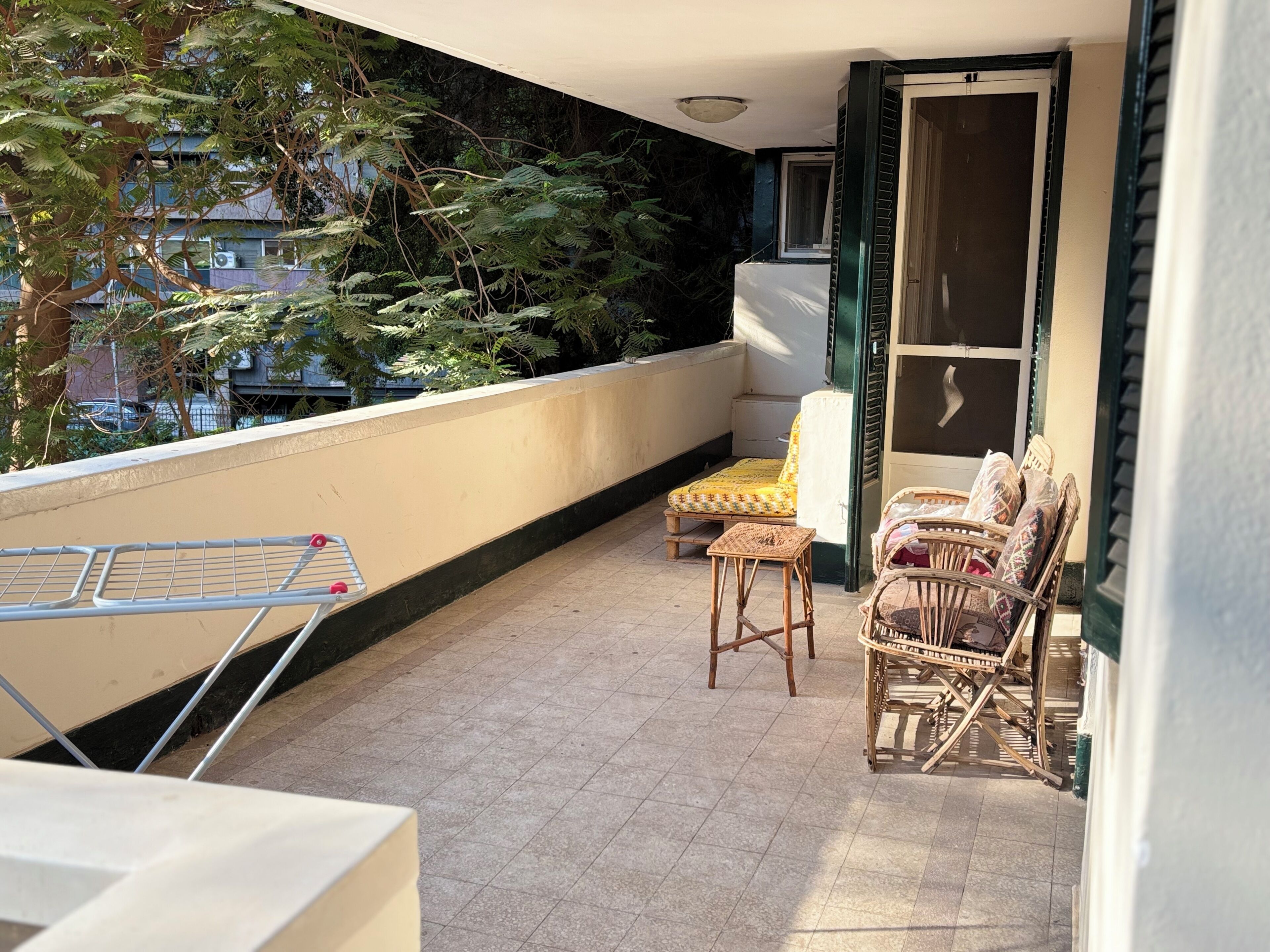 A balcony with a seating area, a window, and a door.