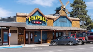 Een Playmill Theater met een opvallende molenstructuur, een toegankelijke ingang voor mensen met een handicap, en een parkeerplaats met auto's.