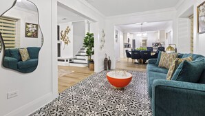 A modern living room with a teal sofa, a patterned rug, and a unique orange coffee table. - Habana Luxury Bungalow- Heated pool (Tampa)