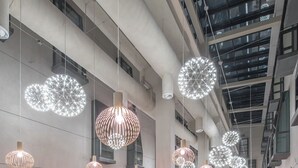 A spacious indoor dining area with high ceilings, modern pendant lighting, and a mix of seating options including tables and benches. - Best Boutique Hotel (Shanghai)