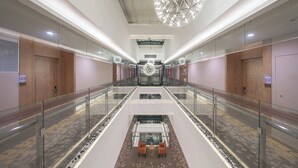 A spacious hotel lobby with a central seating area, glass railings, and a large spherical chandelier. - Best Boutique Hotel (Shanghai)