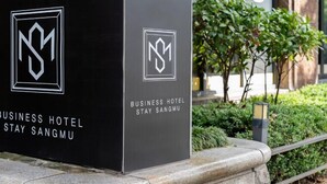 A black signboard for a business hotel with a logo and the name 'STAY SANGMU'. - STAY SANGMU (Gwangju)