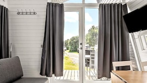 Una habitación acogedora con un sofá, una mesa de comedor y cortinas.