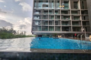 A modern building with a swimming pool in front. - My Misto Homestay, Riverson Soho (Kota Kinabalu)