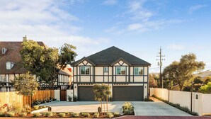 A modern two-story house with a dark roof and a garage. - 2 bedroom - WiFi, AC, garaged off-street parking with EV Charger. (Solvang)