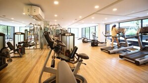 A gym with treadmills, weight machines, and a large window.
