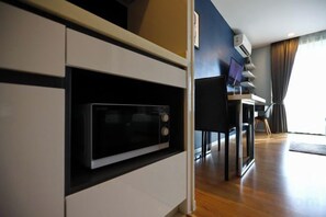 A modern kitchen with built-in appliances, a dining area with a table and chairs, and a large window with curtains. - Vacation Home Rental The Starhillcondo Chiang Mai (Chiang Mai)