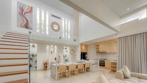 Een moderne keuken met een centraal eiland, houten kastjes en een groot raam.