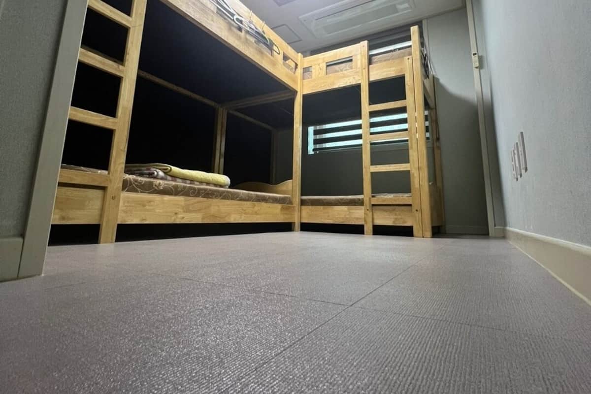 A bunk bed room with a skylight, a small desk, and a carpeted floor.