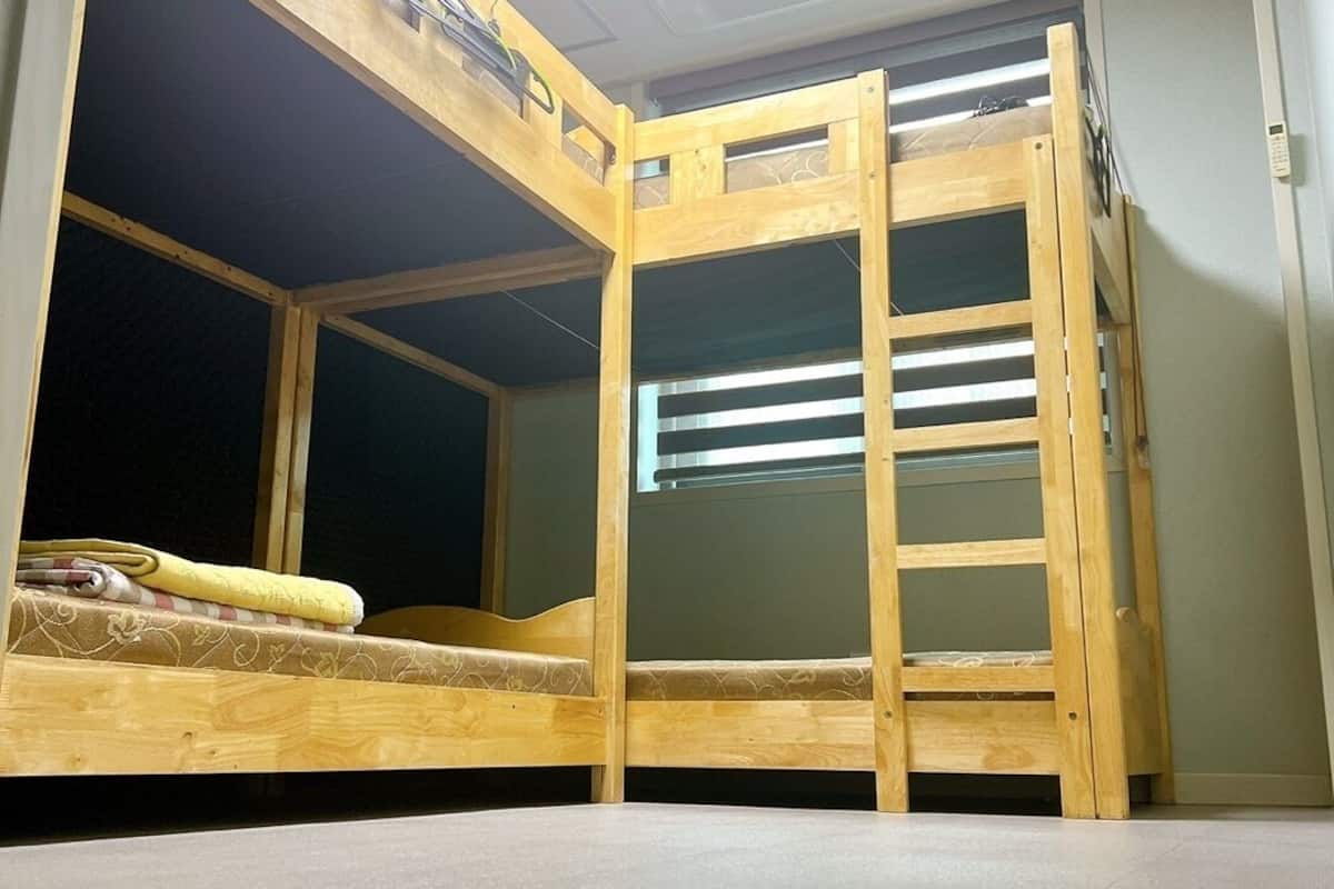 A bunk bed room with a skylight, a heater, and a small window.