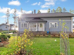 A residential house with a front porch, a lawn, and a garden with trees and shrubs. - Rehviranta by Interhome (Kuopio)