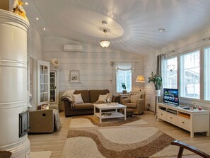 A living room with a sofa, coffee table, TV, and a fireplace. - Rehviranta by Interhome (Kuopio)