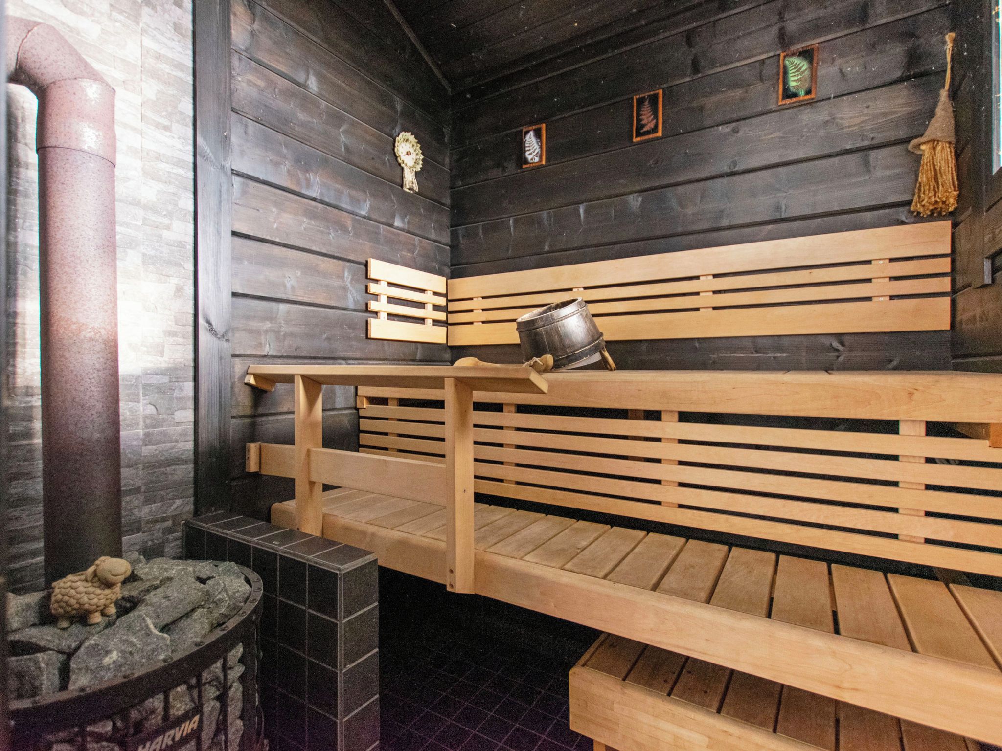 A sauna with wooden benches and a stone basin.