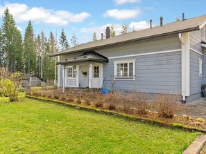 A two-story house with a porch, a front yard, and a forest in the background. - Rehviranta by Interhome (Kuopio)