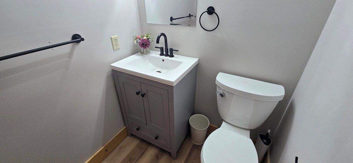 Un bagno piccolo con un lavandino bianco, un water e un armadietto.
