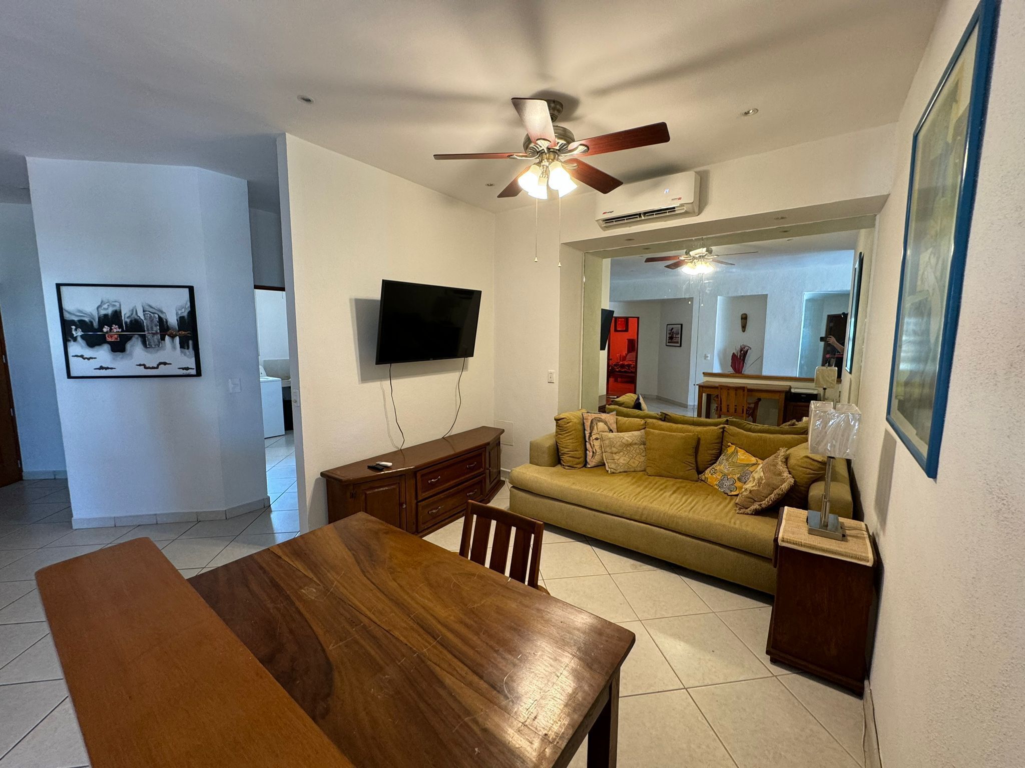 A living room with a wooden table, sofa, and TV.