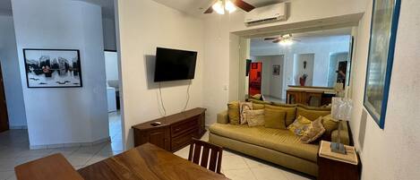 A living room with a wooden table, sofa, and TV.
