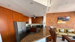 Una cucina moderna con ripiani in granito, elettrodomestici in acciaio inossidabile e mobili in legno.