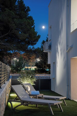A modern outdoor area with a pool, lounge chairs, and a building with a white facade. - Smash A - Apartments with Private Heated Pool (Novalja)