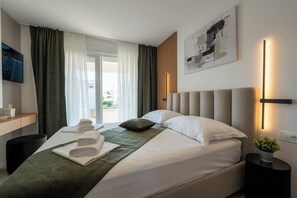 Une chambre d’hôtel avec un lit, une table de chevet, une télévision et une vue sur l’extérieur.