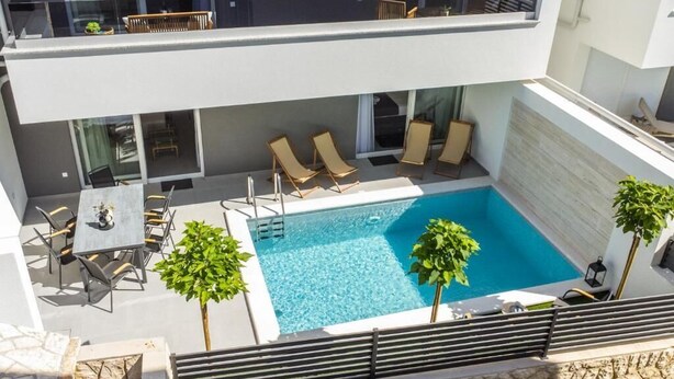 A rooftop pool area with lounge chairs, a table, and a staircase leading to an upper level. - Smash A - Apartments with private pool  (Novalja)