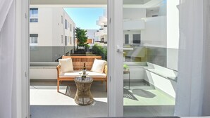 A modern balcony with a wooden sofa, a round wicker table, and a bottle of wine. - Smash A - Apartments with private pool  (Novalja)