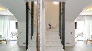 A modern staircase with white steps and black railings, leading to a landing with a lantern. - Smash A - Apartments with private pool  (Novalja)