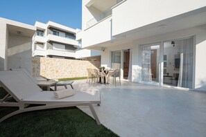A modern outdoor living area with a pool, lounge chairs, and a stone wall. - Smash A - Apartments with Private Heated Pool (Novalja)