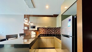 Una cocina moderna con una isla central, electrodomésticos de acero inoxidable y un salpicadero a cuadros.