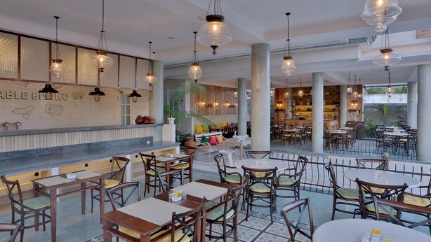 A restaurant with a bar area, multiple tables and chairs, and a view of the outdoors. - SOLTERRA SEMINYAK Boutique Hotel & Spa Powered By Archipelago (Keroboken Kelod)