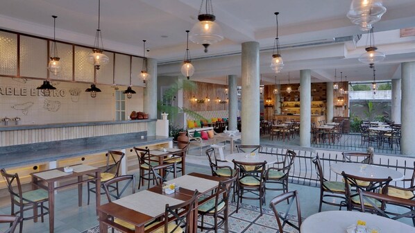 A restaurant with a bar area, multiple tables and chairs, and a view of the outdoors. - SOLTERRA SEMINYAK Boutique Hotel & Spa Powered By Archipelago (Keroboken Kelod)