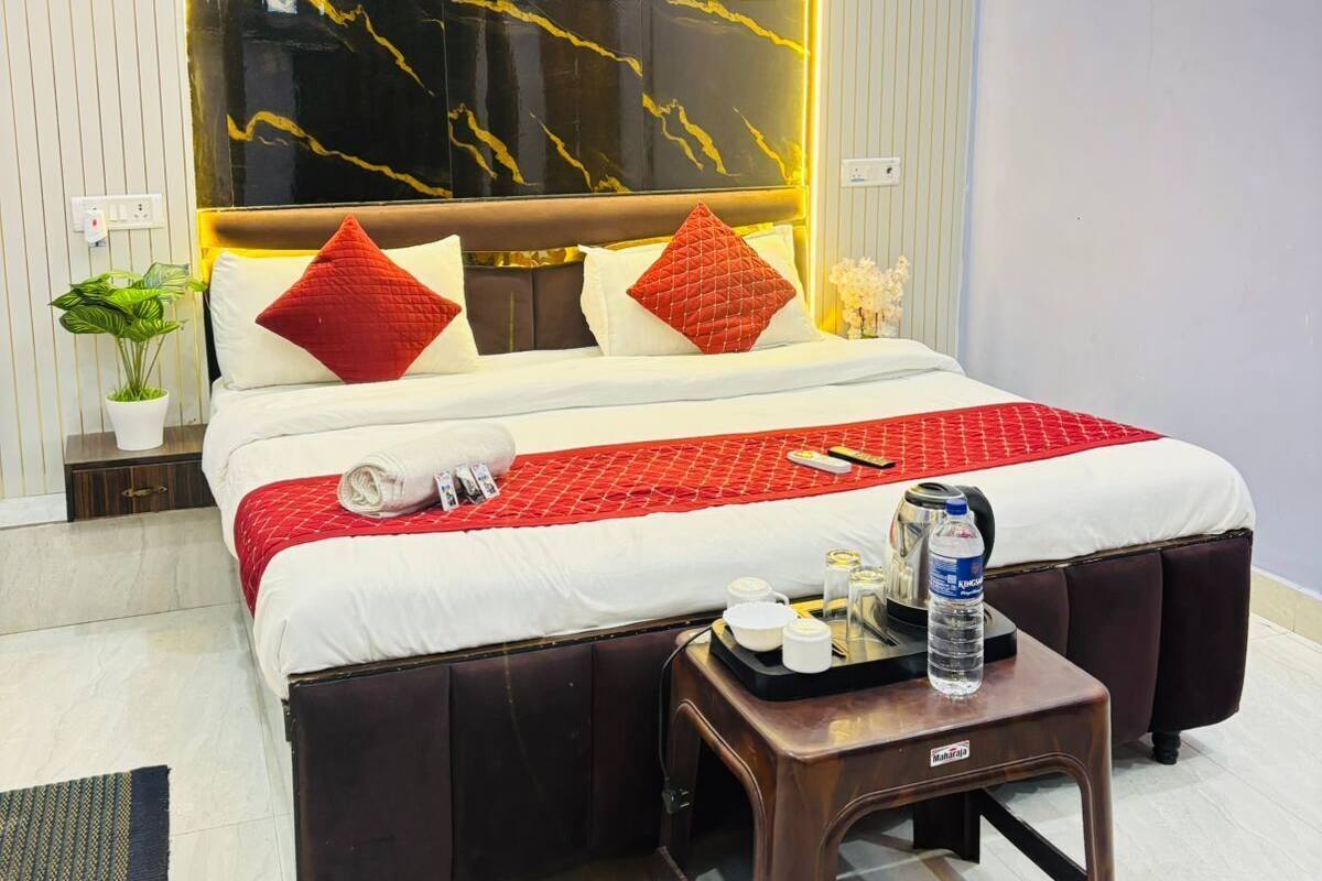 A hotel room with a bed, a bedside table with a bottle, and a wall with a marble-like design.